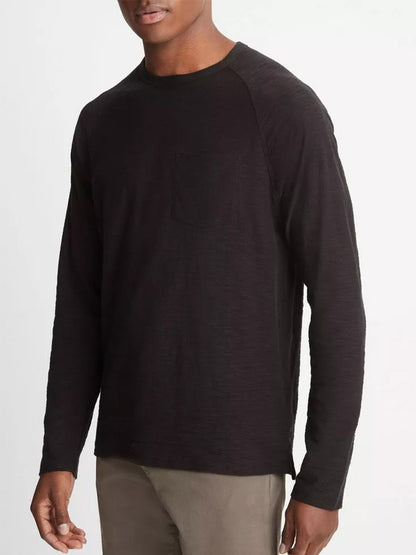 Man wearing a Vince Cotton Long Sleeve Pocket Crew T-Shirt in black with khaki pants against a white background.