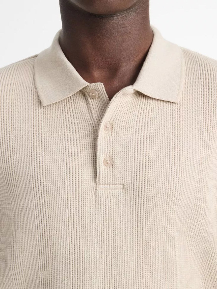 Close-up of a person wearing a Vince Variegated Pima Cotton Polo Shirt in Dark Morning Haze made from luxurious Pima cotton with three buttons fastened at the collar.