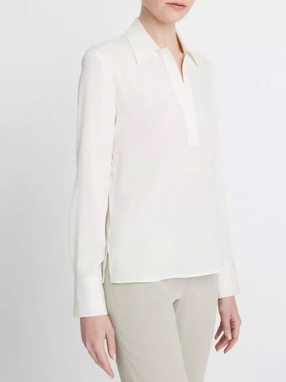 Woman wearing an elegant Vince Stretch-Silk Long-Sleeve Polo Blouse in Off-White with a collar and beige trousers.