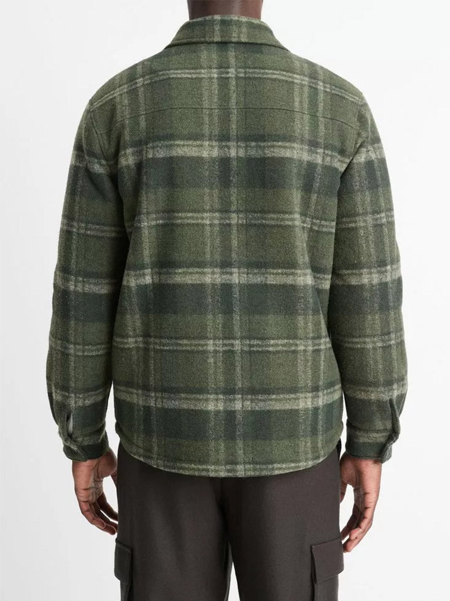 A person wearing the Vince Sherpa-Lined Plaid Shirt Jacket in Night Moss Combo paired with dark pants, viewed from the back.