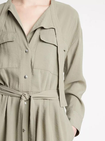 Close-up of a woman wearing a Vince Soft Utility Shirt Dress in Sea Fern with a tie waist.