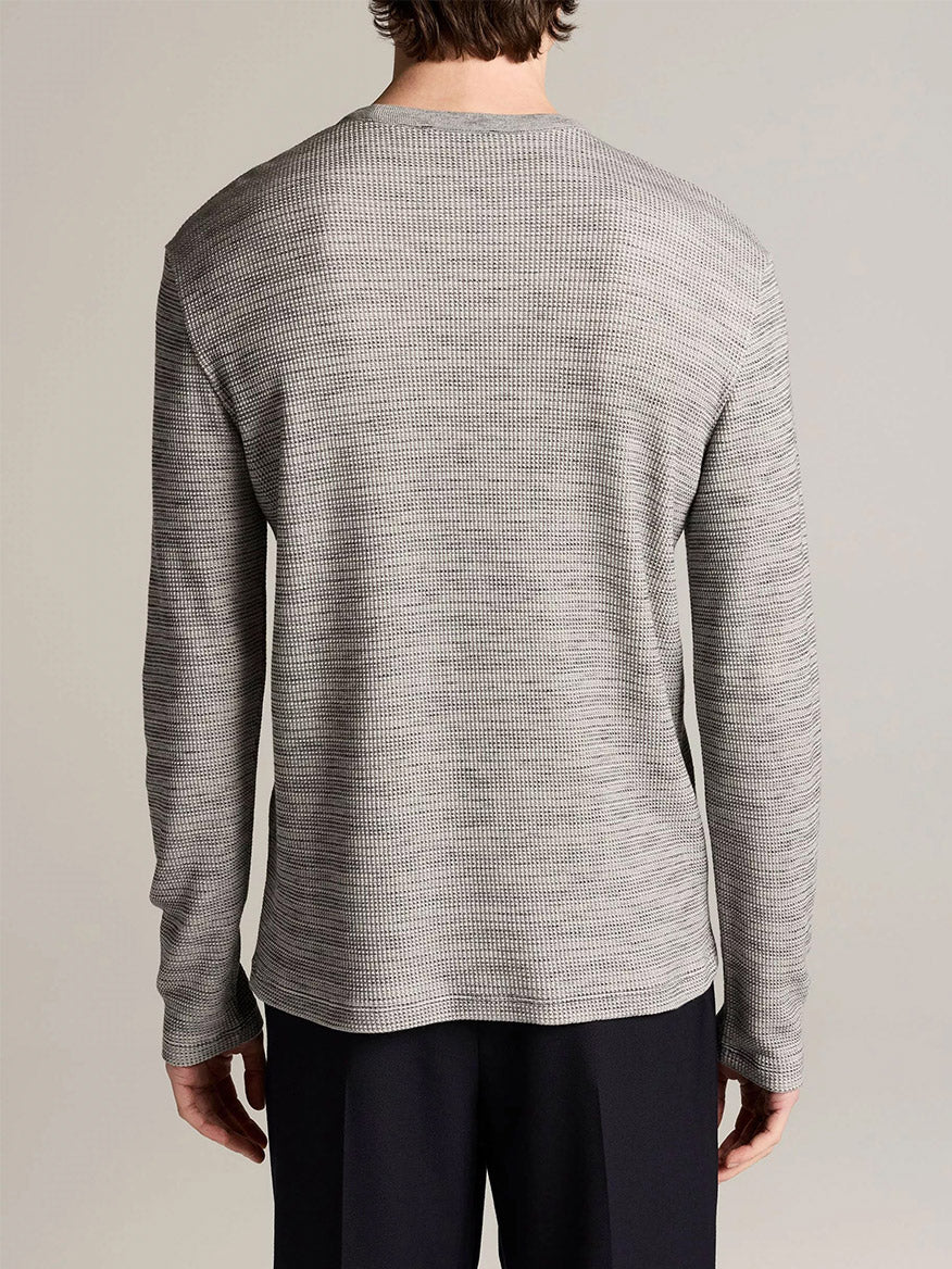 Person facing away from camera wearing the Vince Space-Dye Cotton-Blend Thermal Long-Sleeve T-Shirt in Late Evening Combo and black pants, standing against a plain background.
