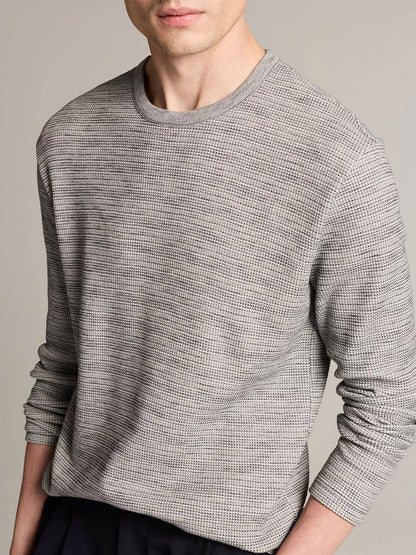 A person wearing the Vince Space-Dye Cotton-Blend Thermal Long-Sleeve T-Shirt in Late Evening Combo stands against a plain background, with their face partially out of frame.