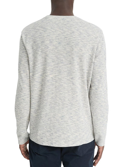 Person wearing the Vince Space-Dye Cotton-Blend Long-Sleeve T-Shirt in Blue Cloud/Off-White and dark pants, showcasing a speckled effect, facing away.