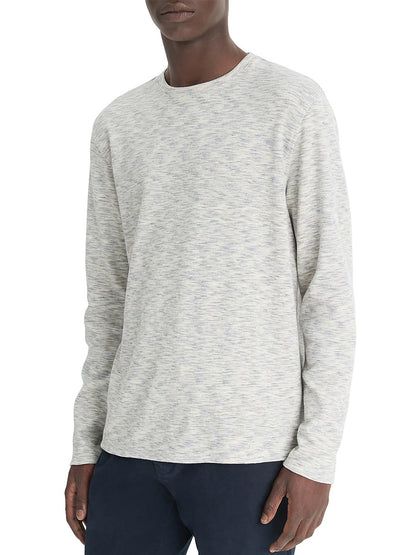 The person is wearing a Blue Cloud/Off-White Vince Space-Dye Cotton-Blend Long-Sleeve T-Shirt, paired with dark pants against a plain white background.