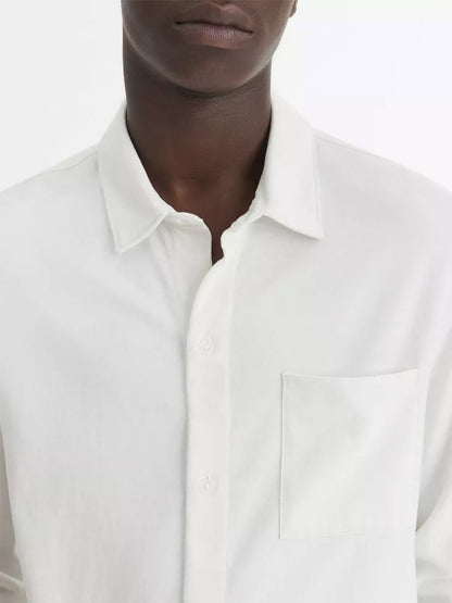 Individual dressed in a Vince Sueded Cotton Jersey Button-Front Shirt in Off-White featuring long sleeves, a chest pocket, and crafted from ultra-soft cotton jersey.