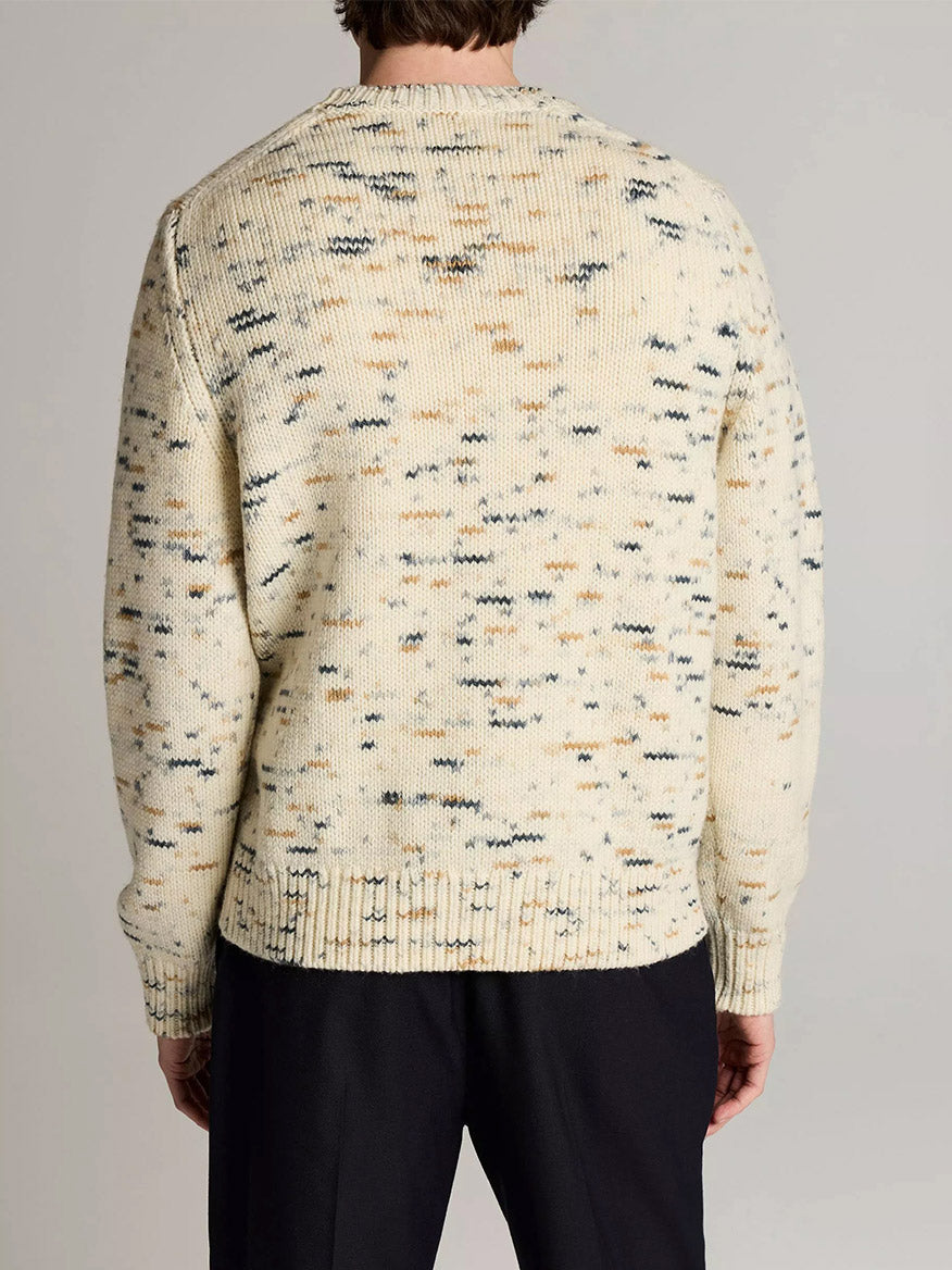 A person wearing the Vince Super Space-Dye Merino Wool Sweater in Bone Combo with black pants, shown from the back against a neutral background.
