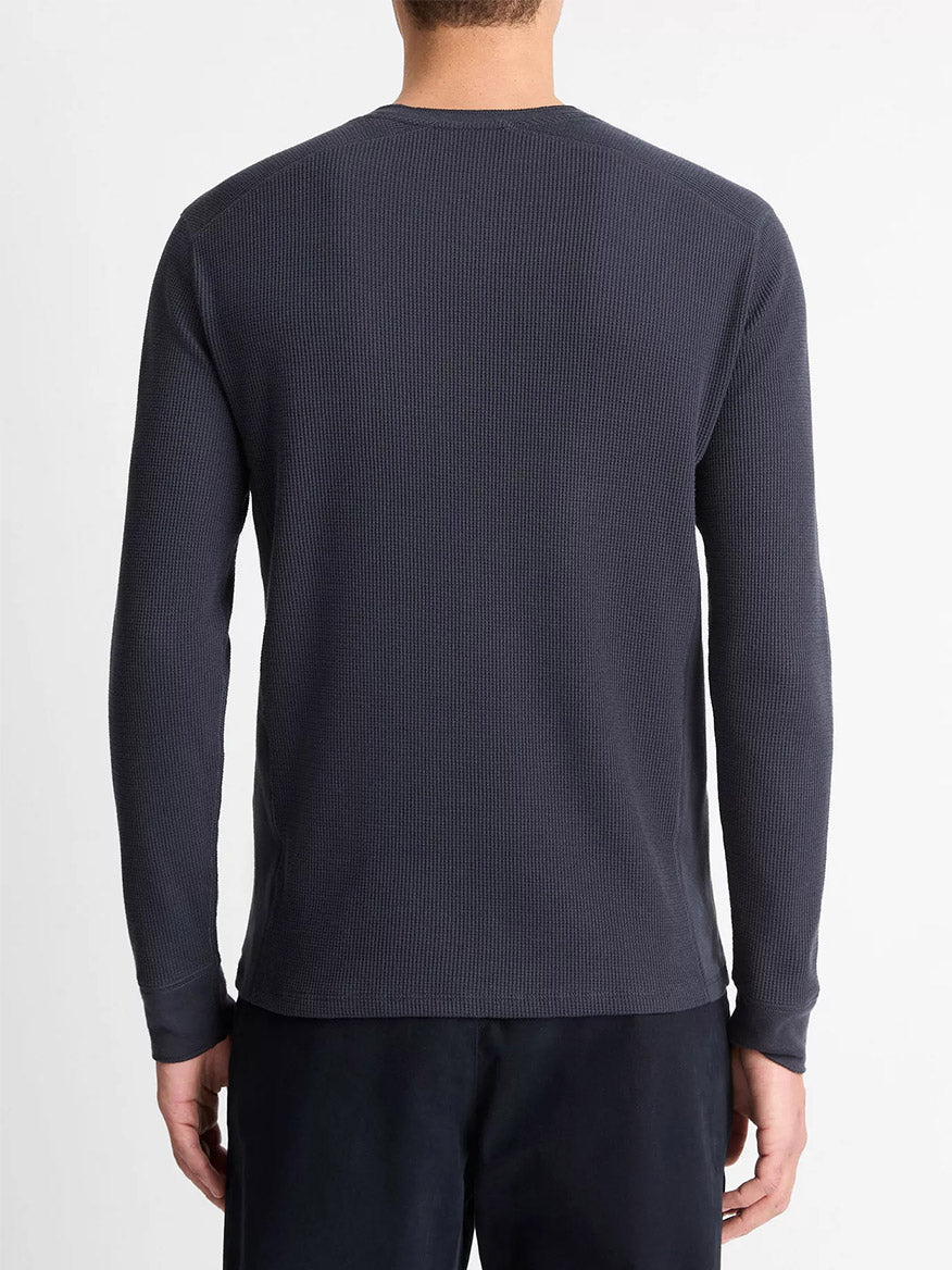 A person is seen from behind wearing a Vince Thermal Long Sleeve Crew Neck Pullover in Coastal Blue and dark pants, standing against a plain white background.