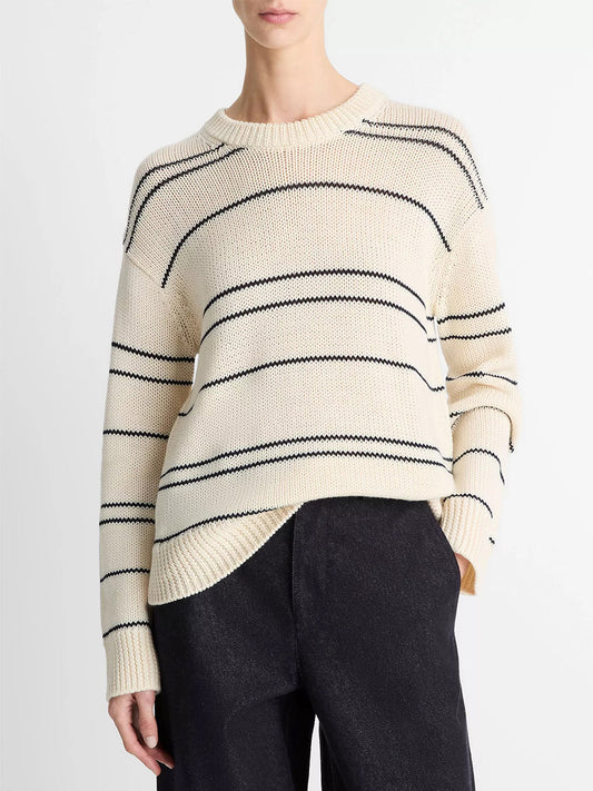 A person wears the Vince Variegated Stripe Wool-Blend Sweater in Oat Shell/Navy with black pants, standing against a plain white background.