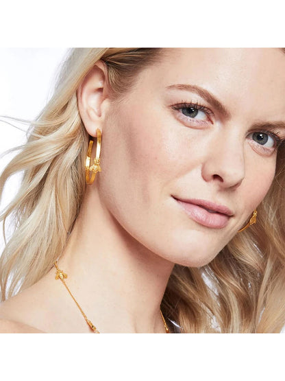 Close-up of a blonde woman wearing Julie Vos Bee Hoop Earring - Large Gold and a matching necklace, smiling subtly.