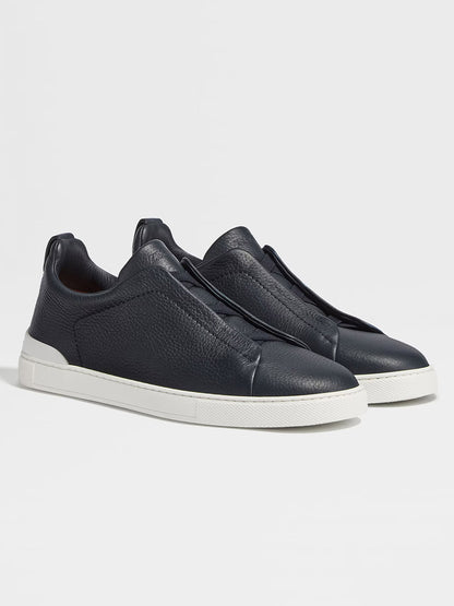A pair of Zegna Navy Blue Deerskin Triple Stitch™ Sneakers with white rubber soles is displayed against a plain light background.