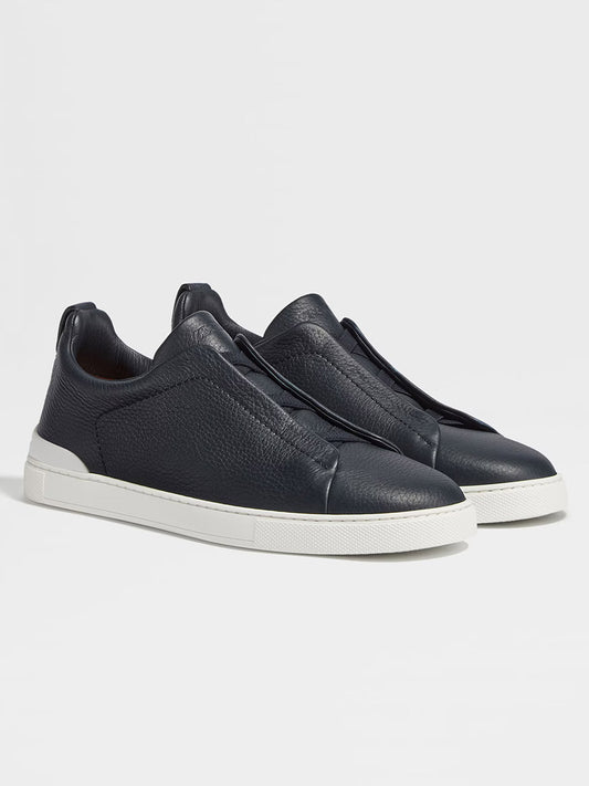 A pair of Zegna Navy Blue Deerskin Triple Stitch™ Sneakers with white rubber soles is displayed against a plain light background.