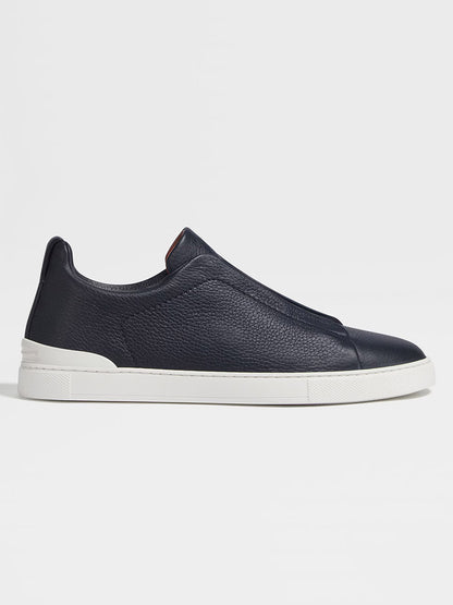 A single navy blue ZEGNA Triple Stitch™ deerskin sneaker with a white rubber sole, displayed on a plain white background.