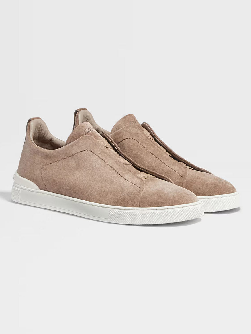 The Zegna Beige Suede Triple Stitch Low Top Sneaker, featuring beige suede material with triple stitch detailing and white rubber soles, is displayed against a plain white background.