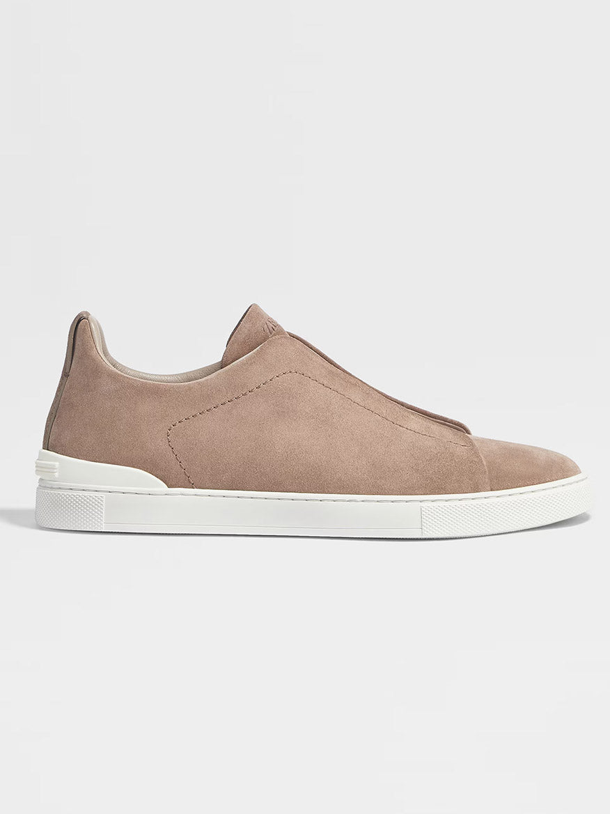 A Zegna Beige Suede Triple Stitch Low Top Sneaker with a white rubber sole, viewed from the side, on a plain grey background.