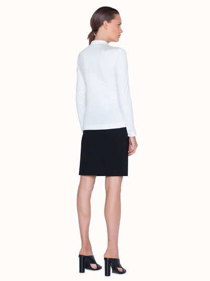 The back view of a woman wearing an Akris Punto Elements Long Sleeve Blouse and black skirt.