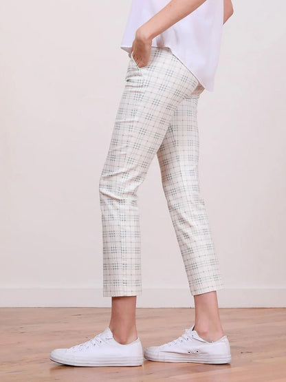 A person wearing Avenue Montaigne Lulu Plaid Blue Ankle Slim Pants with side pockets, paired with white shoes.