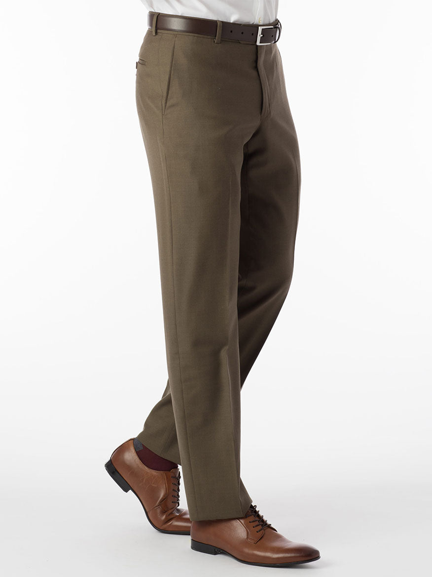 A man dressed in Ballin Soho Comfort 'EZE' Super 120s Modern Flat Front Pant in Olive is standing on a white background, exuding an air of luxury and comfort.