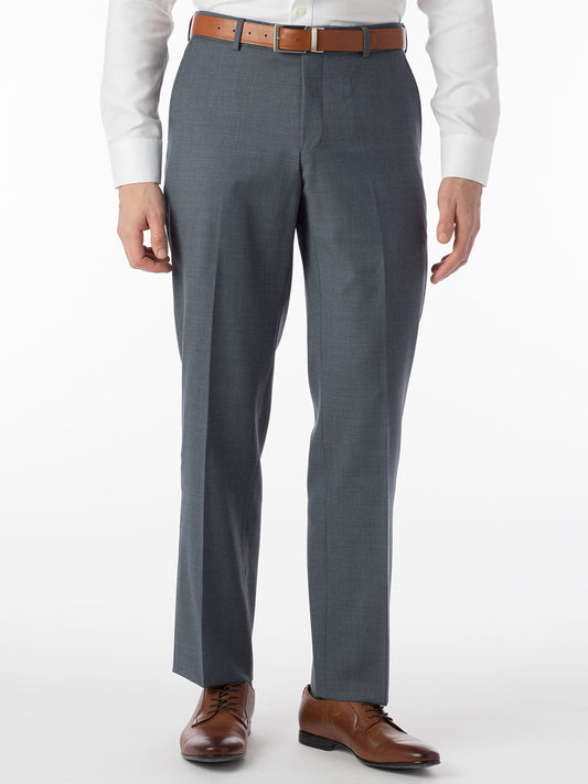 A man exudes luxury, comfortably standing in a gray suit with Ballin Soho Comfort 'EZE' Super 120s Modern Flat Front Pant in Slate Blue shoes.