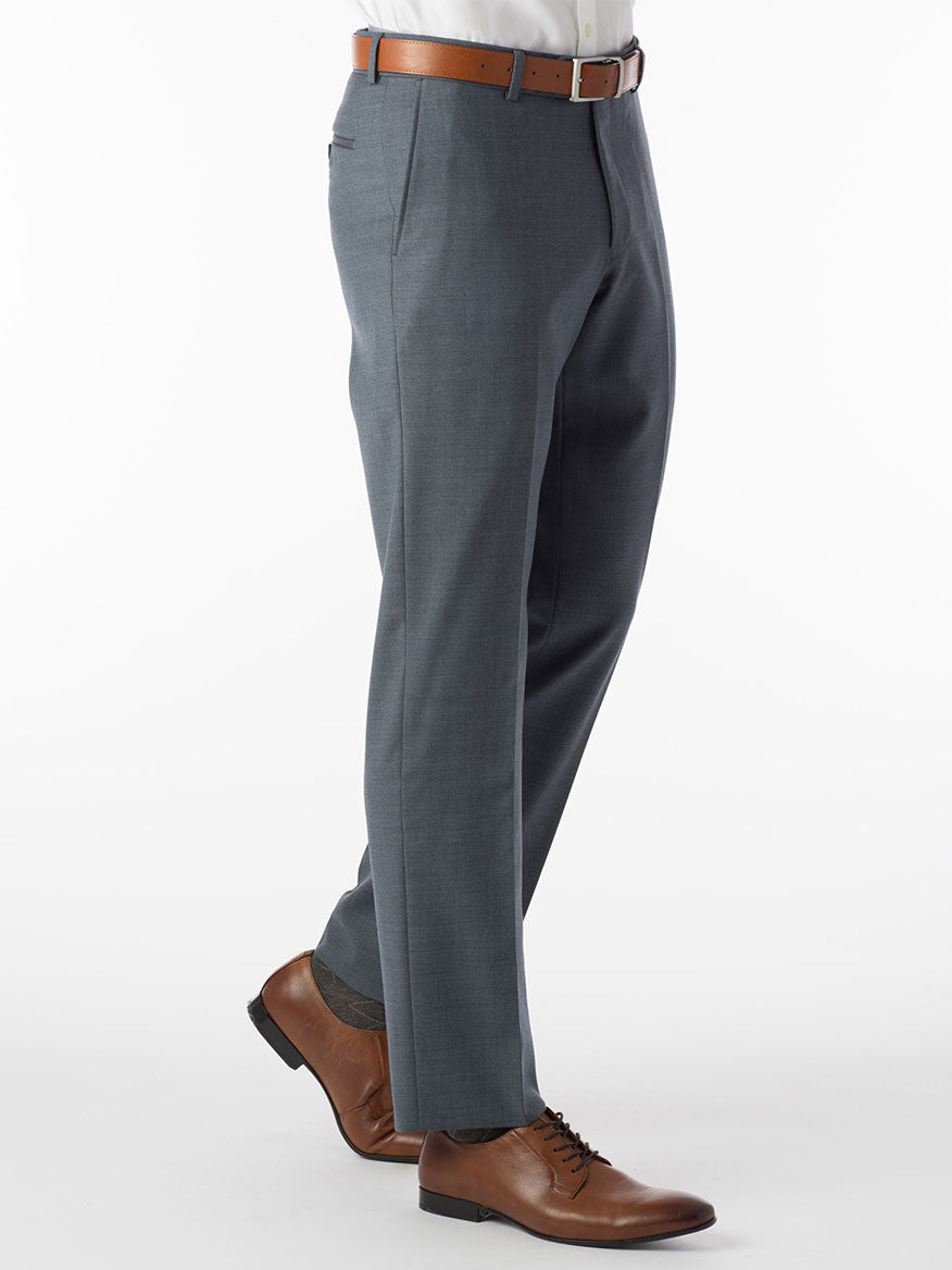 A man is standing in a gray suit with brown shoes, exuding both comfort and luxury wearing the Ballin Soho Comfort 'EZE' Super 120s Modern Flat Front Pant in Slate Blue.