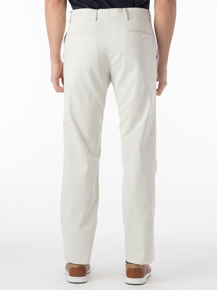 A person is wearing Ballin Atwater True Khaki Modern Flat Front Pant in Stone and brown shoes, shown from the back against a white background.