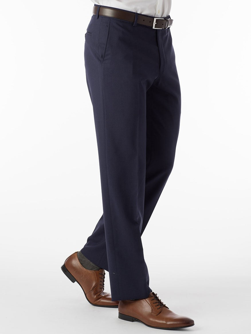 A man is standing in a blue suit featuring a Ballin Soho Comfort 'EZE' Super 120s Modern Flat Front Twill Pant in New Navy and stylish tan shoes.