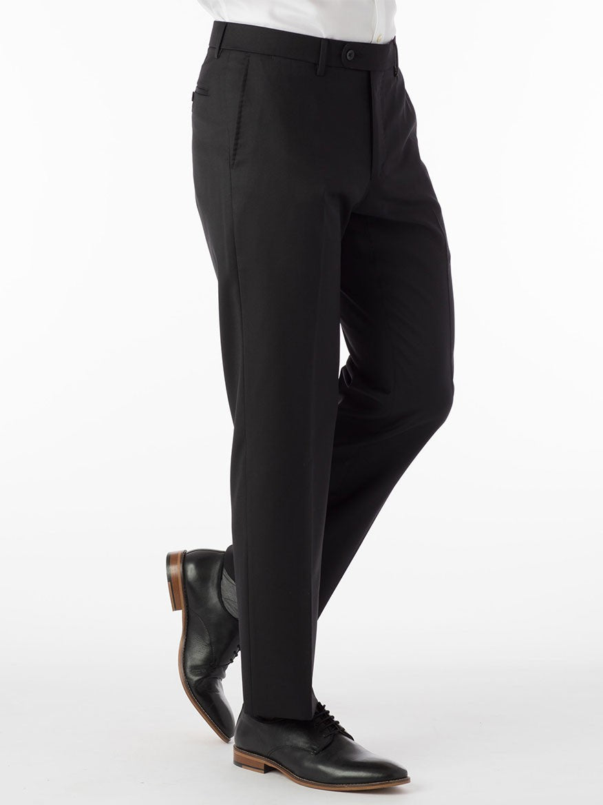 A man wearing Ballin Houston Super 130s Modern Flat Front Pant in Black and a white shirt, showcasing a touch of luxury from Loro Piana, Italy.