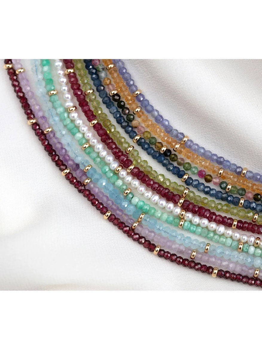 A multi-colored beaded EF Collection Birthstone Necklace with Gold Rondelles - Tanzanite, nestled on a white background.