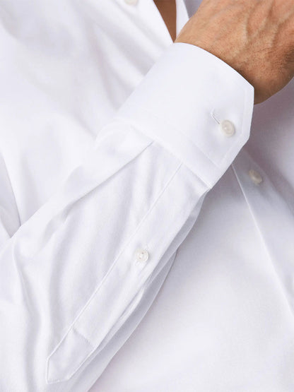 A close-up of a person's arm in an Eton Slim Fit White Stretch Twill Dress shirt, focusing on the cuff with buttons.
