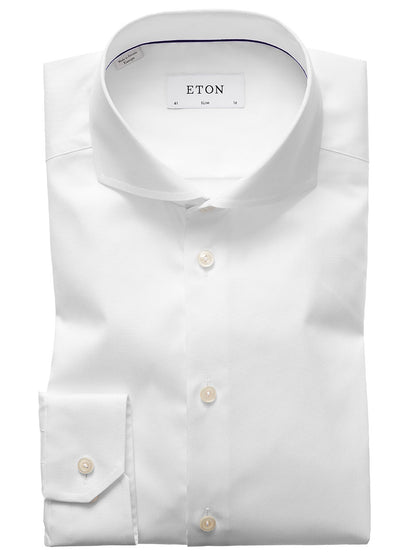 The Eton Slim Fit White Extreme Cut Away Dress Shirt features an extreme cut away collar and buttoned cuffs, neatly folded and displayed against a plain background.