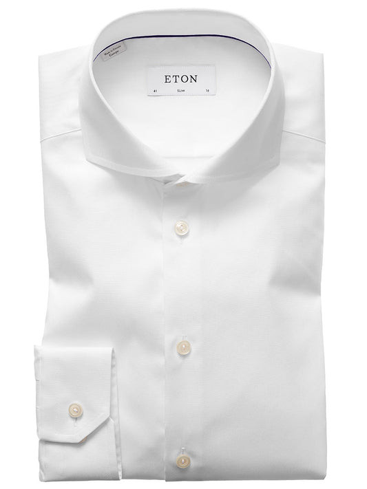 The Eton Slim Fit White Extreme Cut Away Dress Shirt features an extreme cut away collar and buttoned cuffs, neatly folded and displayed against a plain background.
