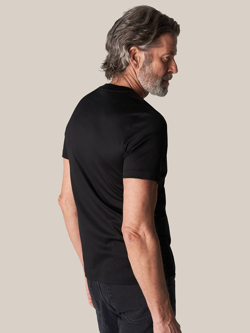 Man wearing a Eton Filo di Scozia T-Shirt in Black and jeans, viewed from the side.