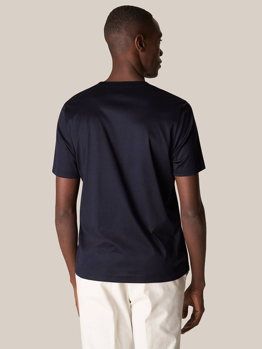 A man viewed from behind, wearing a luxurious double mercerized Eton Filo di Scozia T-Shirt in Navy and off-white trousers.