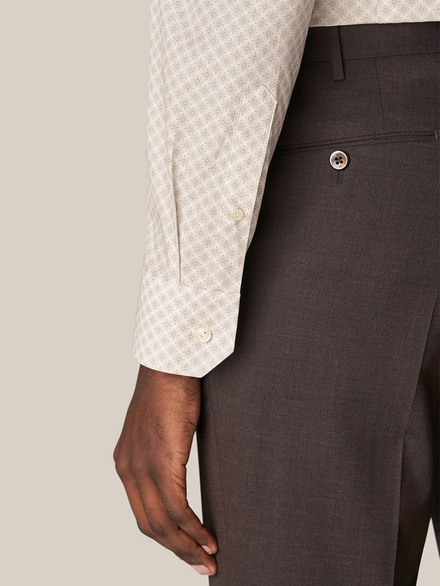 Close-up view of a person wearing Eton's Brown Signature Poplin shirt in Medallion Print and dark brown dress pants, focusing on the shirt cuff and pants pocket area.