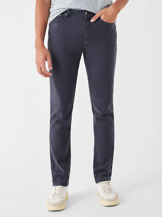 A person wearing their favorite pair of pants in dark blue, the Faherty Brand Stretch Terry 5-Pocket Pant in Navy.