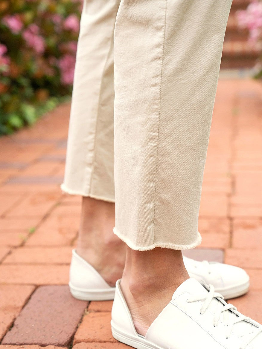 Person wearing Frank & Eileen Wicklow Italian Chino in Khaki and cream-colored pants with a mid-rise waistband standing on a brick pathway.