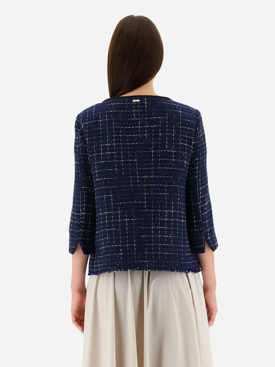 Back view of a person wearing a Herno Jacket in Casual Tweed in New Blue with three-quarter sleeves and a light beige skirt against a white background.