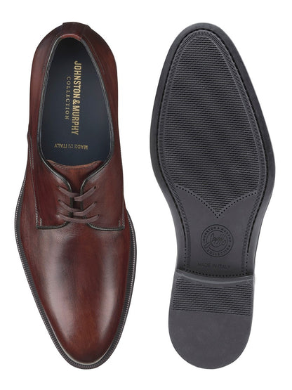 A pair of J & M Collection Flynch Cap Toe in Mahogany Italian Calfskin derby shoes from Italy on a white background.