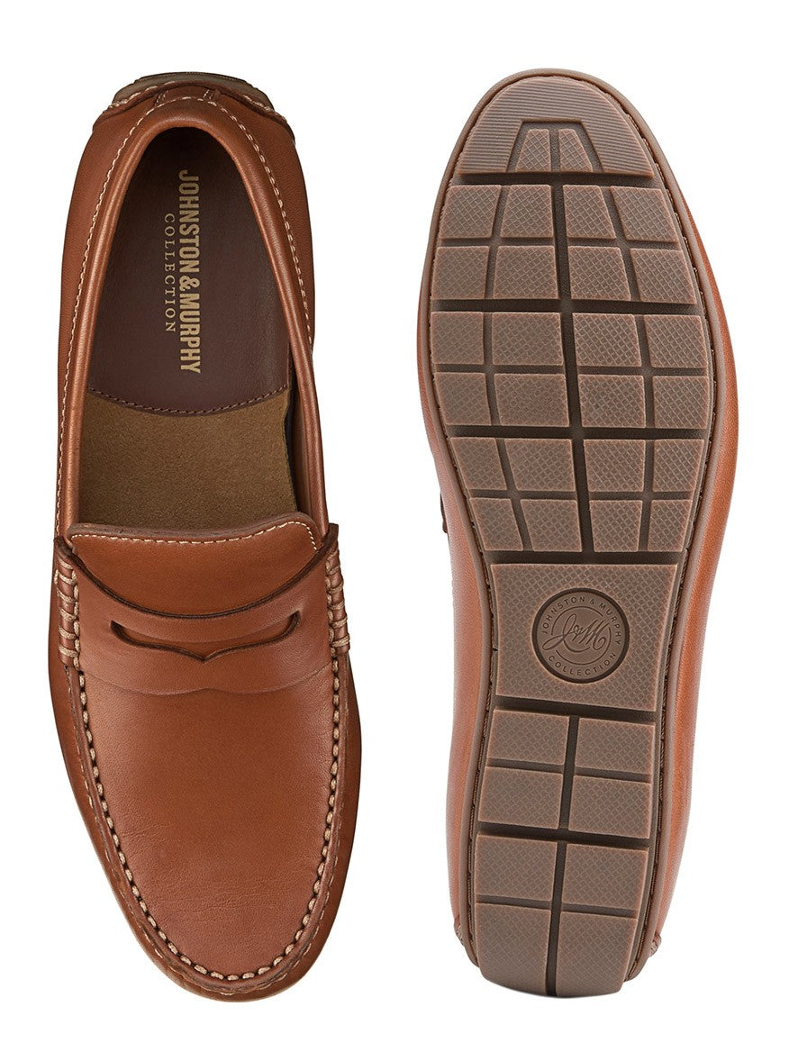 A pair of J & M Collection Baldwin Driver Penny in Cognac Sheepskin loafers featuring a sheepskin lining, with a top and bottom view showing the shoe design and tread pattern.