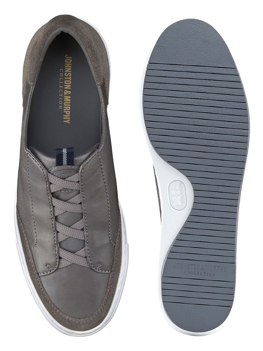 A pair of J & M Collection Anson Stretch Lace-to-Toe Grey English Suede/Sheepskin sneakers with white soles.