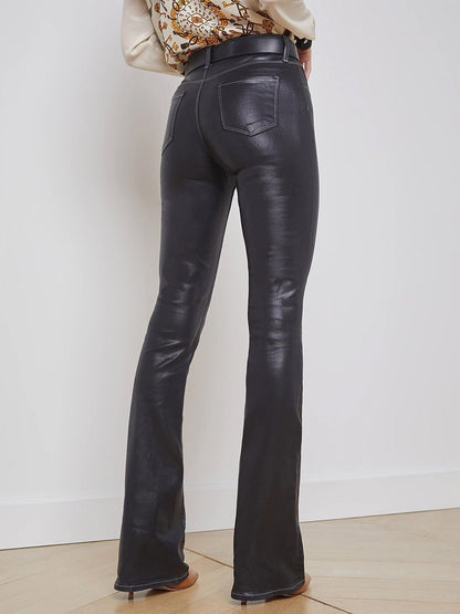 The back view of a woman wearing L'Agence Selma Coated Jean in Noir/Natural Contrast Coated flared pants.