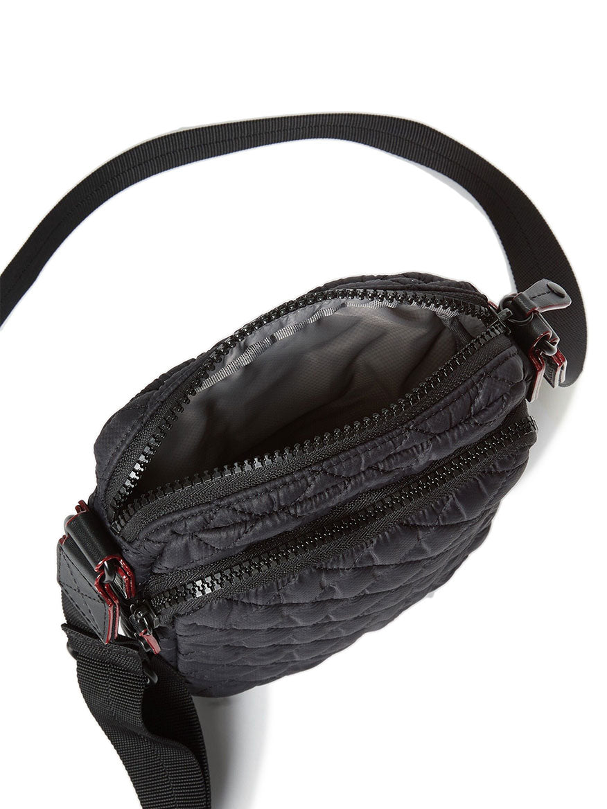 The MZ Wallace Metro Crossbody in Black Oxford features Italian leather trim, a quilted design, an open zippered compartment, and an adjustable strap for versatile style.