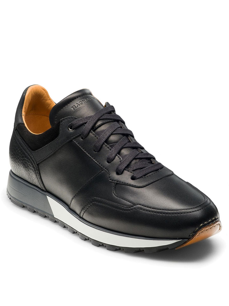 The Magnanni Arco in Black is a retro-inspired low-top sneaker with brown accents, featuring a hand-stitched leather toe. A lace-up front provides a secure fit, while the textured outsole ensures lightweight, flexible comfort all day.