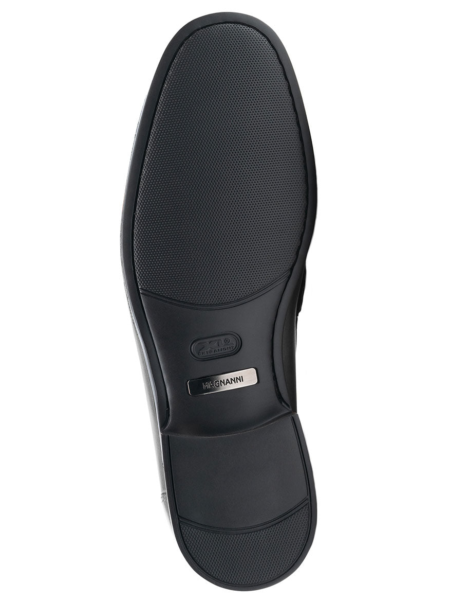 A close-up view of the bottom sole of the Magnanni Blas II in Black showcases its cushioned rubber sole with a textured grip and a metal nameplate reading "MAGNANNI" near the heel. This exquisite bit loafer is handmade in Spain, flawlessly combining style and comfort.