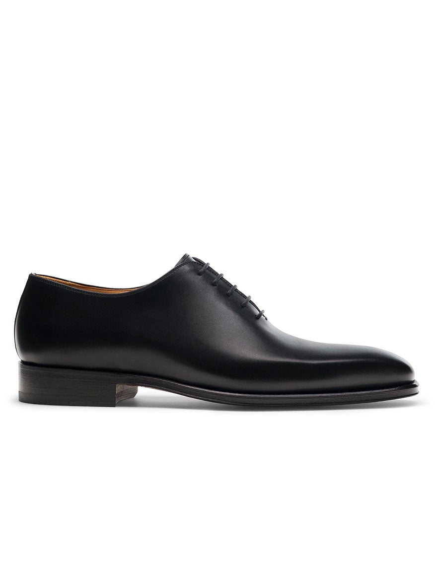 The Magnanni Crucero in Black is a whole cut Oxford dress shoe featuring black leather, closed lacing, Bologna construction, and a low stacked heel, shown in profile on a white background.