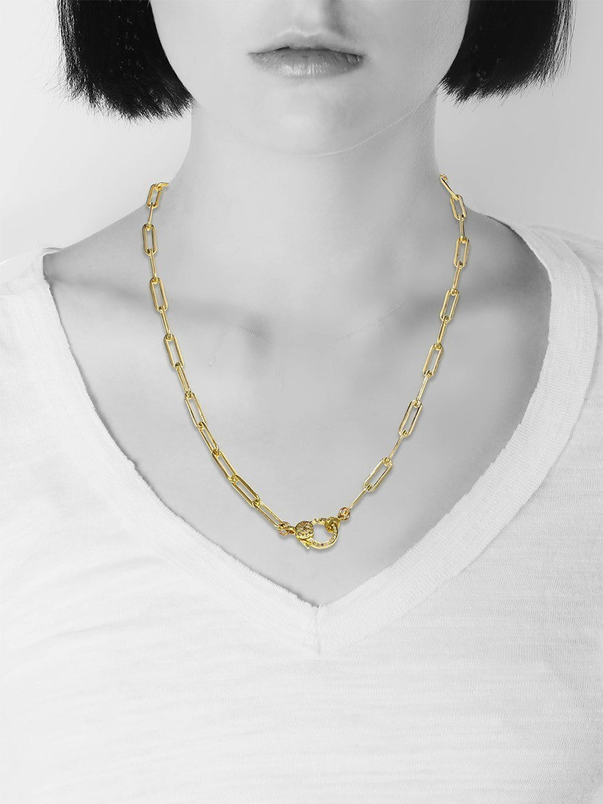 Woman wearing a Margo Morrison Gold Paper Clip Chain with Diamond Clasp necklace with pendant, white top, and black bob haircut.