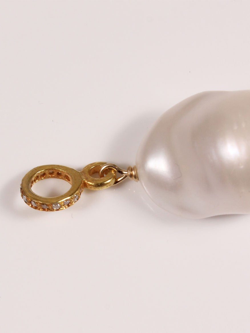 Margo Morrison White Baroque Pearl Charm with Gold Diamond Ring lying next to a baroque pearl charm on a white surface.