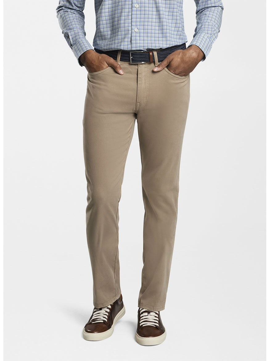 A man wearing the Peter Millar Ultimate Sateen Five-Pocket Pant in Grain and a blue shirt.
