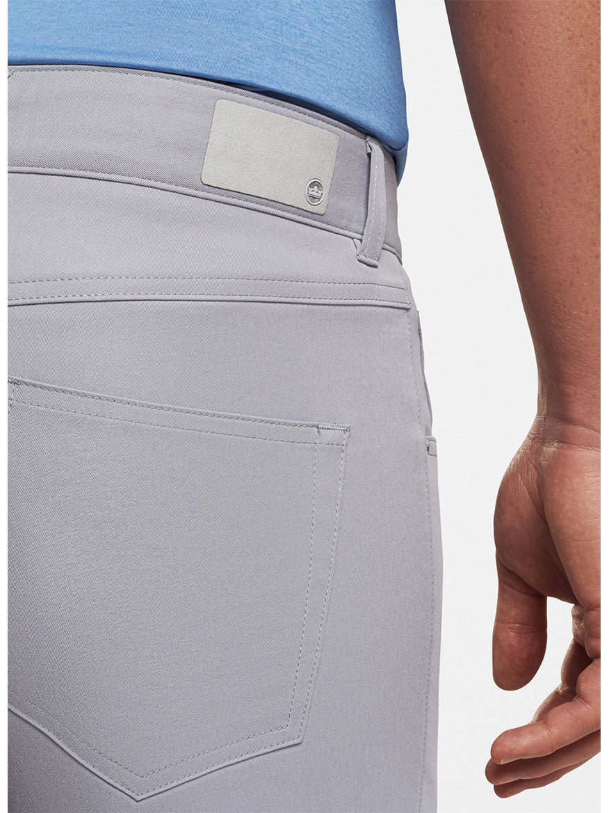 The back view of a PGA Tour player wearing Peter Millar Performance Five-Pocket Pant in Gale Grey.