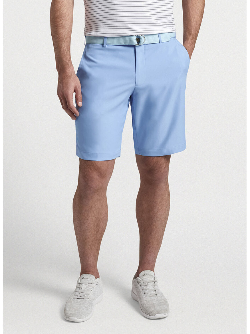 Man wearing the Peter Millar Salem High Drape Performance Short in Cottage Blue and white sneakers.